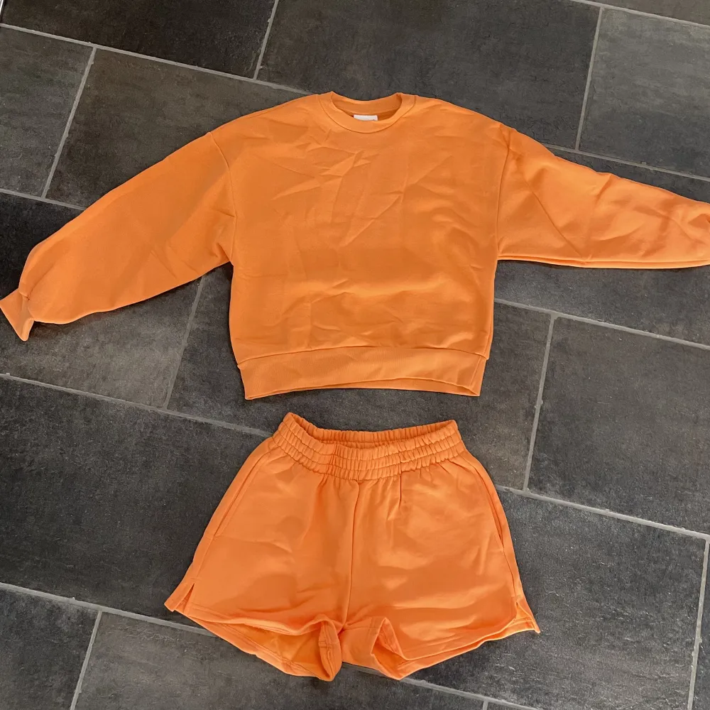 Mjukisset med shorts och sweatshirt i en somrig orange färg!  Shorts i storlek S  Tröja i storlek XS Går även att köpa separat! Isåfall tröjan för 200kr och shorts för 150kr. Men hela setet för 300kr  . Hoodies.