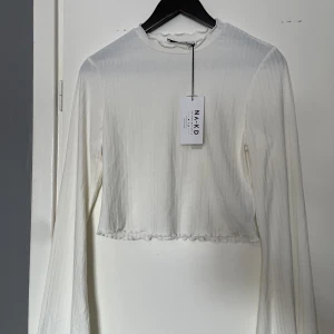 Croptop - Vit Croptop från Nakd i storlek M med trumpetärmar. Oanvänd. 