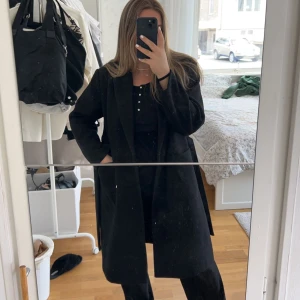 Svart lång kappa - Säljer denna svarta kappa från Only, köpt på Nelly, i storlek L, men mer som M. Köpt för 669kr men säljs för 350kr