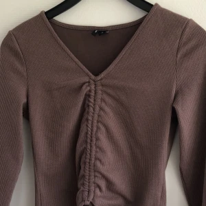Nougatfärgad topp  - Säljer nu en jättefin nougatfärgad topp. Jätteskönt material, knappt använd. Möjlighet att justera längden finns med hjälp av snörena. Säljs på grund av brist på användning. Rensar bland kläderna så kolla gärna mina andra annonser också🤗