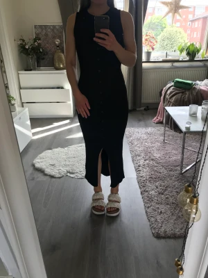 Klänning från topshop - Aldrig använd. Mjukt stretchigt material. Slits framtill och knappar längs hela framsidan. Säljer pga lite för stor för mig
