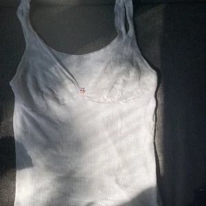 Vitt ribbat linne med spets  - Jättefint ribbat linne med genomskinlig spets över brösten! 