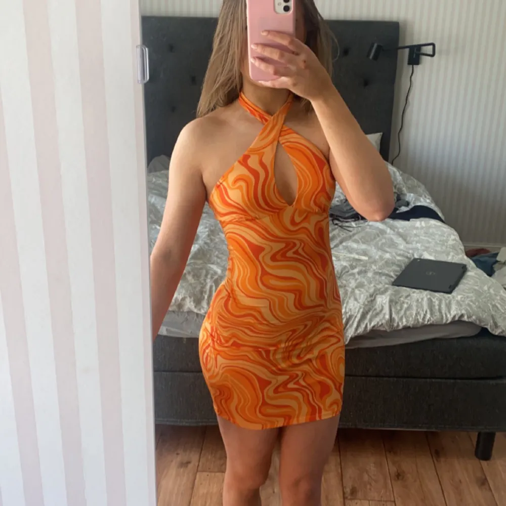 Orange klänning perfekt till sommaren och semester. Storlek XS. Går att både ha knuten där fram som på bilden eller ha den som vanligt. Endast använd en gång så precis som ny!💛 Köparen står för frakt!. Klänningar.