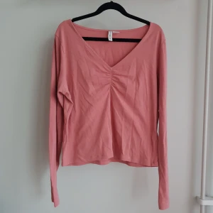 Topp - Enkel rosa, långärmad topp. Är mjuk och stretchig i materialet. Har använts ett fåtal gånger men är i ett fräscht skick.