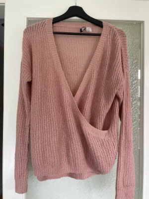 Stickad tröja - En rosa stickad tröja som korsas fram till. 