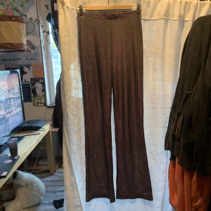 Glitter byxor - Utsvängda byxor. Använda få gånger. Glittret åker av ganska enkelt på andra saker. Stretchigt material.