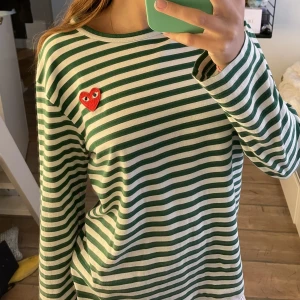 Comme Des Garcons tröja - Comme Des Garçons Play tröja! Grön vit randig, Perfekt nu till skolstart och till hösten! Köptes för 1687kr! Storlek S! Inga defekter! Byter jättegärna!! Skriv för fler frågor eller bilder!!❤️❤️☺️