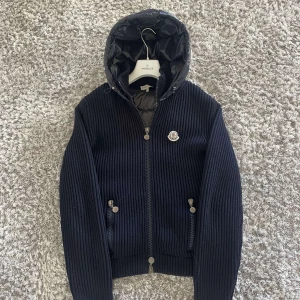 Moncler hooded cardigan - Tja, säljer nu en sjukt fet moncler cardigan som är i en ganska ovanlig modell. Cardiganen är i storlek large men passar Meduim. Har ett sjukt bra skick som ligger på 9/10. Og finns🥰 Vid fler frågor och funderingar är det bara att ta kontakt med mig :)🤝