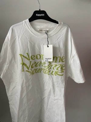 T-shirt med tryck - Vit t-shirt med grånt text tryck. Är även oanvänd och har lappen kvar.