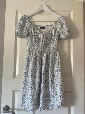 Blommig klänning  - Jättefin och somrig klänning från bikbok! Klänningen är i ett jätte skönt och svalt material, med blå blommor på! Använd 3 gånger. St S❤️❤️