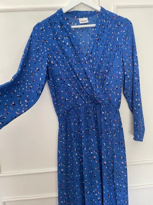 Blå långärmad midiklänning  - Blå långärmad, v-ringad, midiklänning, luftig och skön.  Inga skavanker 