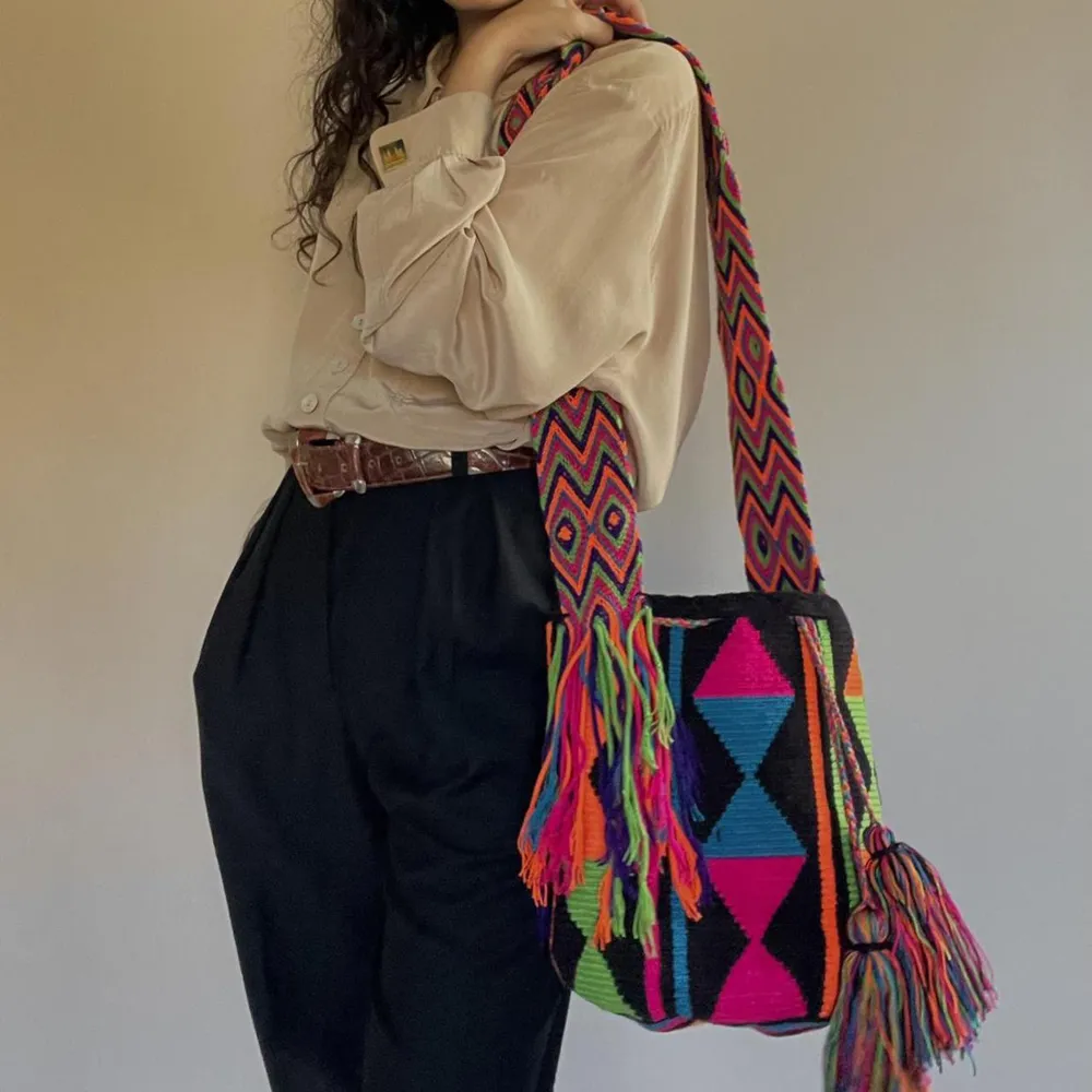This vintage Mochila bucket bag is made in Colombia with colorful threads made of Cotton and Aloe.   The braided shoulder strap can be easily adjusted by tying a knot to shorten. Drawstring Closure with Fringed Tassels. Väskor.
