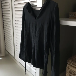 Blus - En svart blus-topp från Sisley. Blusen är veckad där fram och har snören längst ner vid armarna. Står ingen storlek men uppskattar den som en Xs/S beroende på hur man vill att den ska sitta. Säljer för 99kr! Köparen står för frakten💖