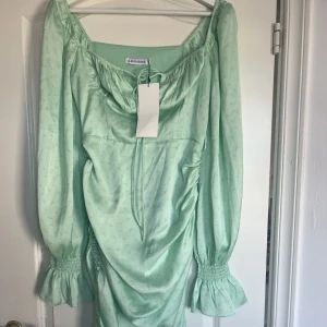 Adoore klänning - Helt ny klänning från Adoore i modellen ”Capri dress” i färgen ”light green” Storlek 40 Drapering på sidan vilket gör att klänningen kan bli en längre modell och en kortare på samma gång Nypris: 1395kr Säljes för: 700kr Köparen står för frakten