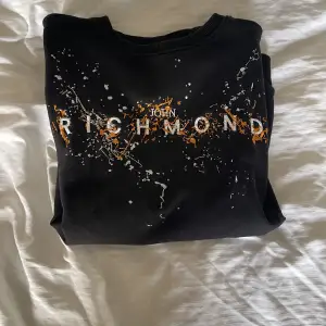 John Richmond sweatshirt med broderat tryck i nyskick. Tröjan är använd 2 gånger och är i nyskick. Fler bilder kan skickas om så önskas. Nypris på farfetch är 253€