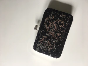 Liten kuvertväska/plånbok - Liten kuvertväska/plånbok med svarta paljetter.  Nyskick, aldrig använd. 