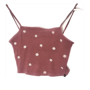 Ljuslila ribbat linne med blommor  - Croppat linne utan justerbara axelband, lite liten i storleken (passar S eller M med mindre byst), aningen mer lila i verkligheten än som syns på bild , prutbart pris 