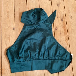 Halternecktopp - Halternecktopp med knyte i ryggen. Aldrig använd. 