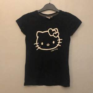En svart t-shirt med Hello Kitty på ifrån Kappahl💕 Inga defekter vad jag kan se. Jag som är en liten S kan få på mig den, men den är tajt i armhålorna!