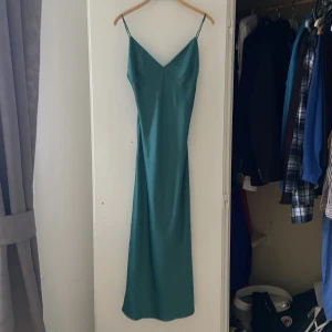 Grön klänning  - Grön klänning, aldrig använd! Prislapp sitter kvar. Slits på sidorna, stl XS.