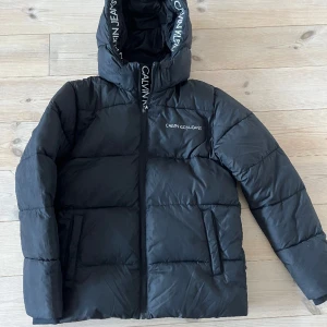 Vinterjacka  - Calvin Klein jacka, storlek 14 år, väldigt sparsamt använd och fint skick. 