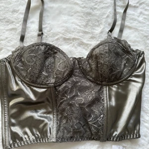 Korsett topp - Korsett top i mörk grön, aldrig använd prislappen sitter kvar. Stl. L men går att justera i ryggen Ny pris 499