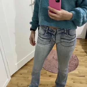 Andra gången jag lägger ut dessa jeans. BUDA BARA OM DU KAN BETALA!! - Lågmidjade jeans. 90-tals och 2000-tals mode. Britney Spears hade på sig sådana som ung. Modernt. Ett hål på ena sidan av byxan, annars jättefint skick. Hålet smälter in med byxans slitdetaljer. Midjemått:75 cm. Jag är 164/165. Se mina andra annonser:) 