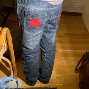 Skitsnygga jeans med påsydda stjärnor på bakfickorna🙏🙏 de är baggy/straightlegged och har snöre i midjan👌👌 midjemått: 38 cm över men det går att dra åt med snörena, ytterbenslängd: 93 cm, innerbenslängd: 70 cm