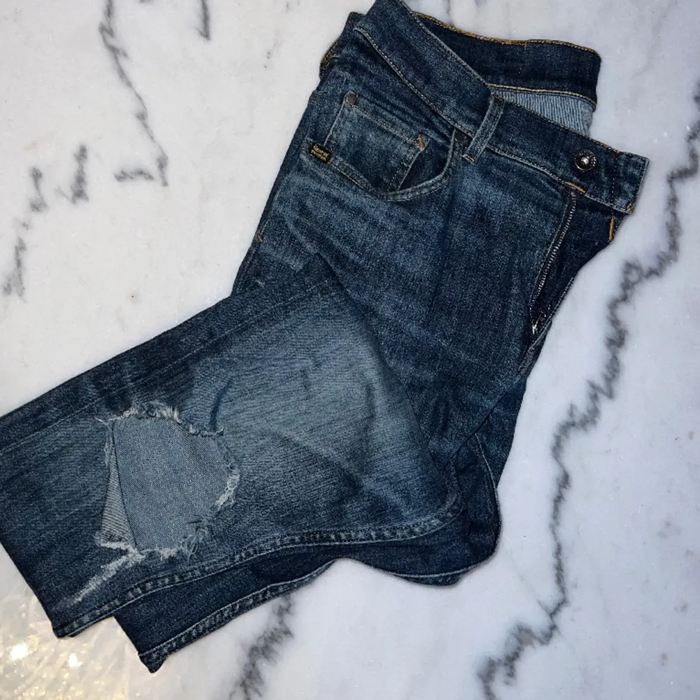 Säljer ett par Tiger Of Sweden Jeans i modellen Slim. Båda knäna har öppningar. Denna modellen är helt slutsåld överallt.. Jeans & Byxor.