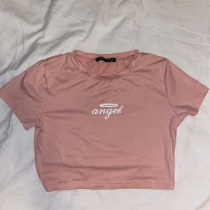 Croppad topp  - Säljer en rosa croppad topp med texten ”angel” på. Från SHEIN och i storlek XS. Använd ett fåtal gånger. OBS: köparen står för frakten. (Annonsen finns ute på fler sidor.)