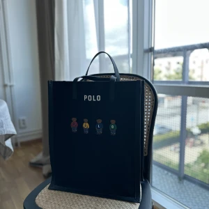 Ralph lauren väska - En nästan helt oanvänd väska från polo ralph lauren! Perfekt som skolväska vilken den även va tänkt till men hittade en annan.   Köpt för ca. 3 år sedan och har bara använts ett fåtal gånger!  Säljer för 1000kr