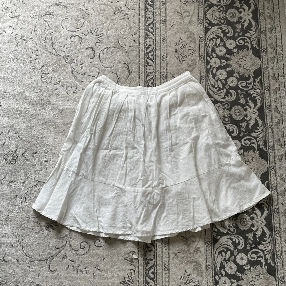 Vit mellanlång kjol av lätt material Aldrig använd  34 cm i midjan, ej stretchig Stryks innan den skickas om så önskas . Kjolar.