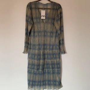 ZARA METALLISK KLÄNNING - Klänning från ZARA med metalliska trådar. Passar såväl till stranden som till en utekväll (genomskinlig). Aldrig använd, ny med tags och utan anmärkningar.