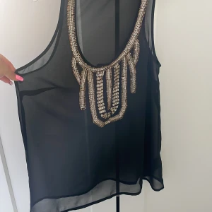 Svart linne - Genomskinligt svart linne/blus med paljetter och stenar
