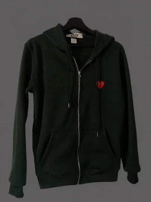 Mörkgrön hoodie från Comme des Garçons - Mörkgrön hoodie med dragkedja från Comme des Garçons PLAY.  Pris kan diskuteras 
