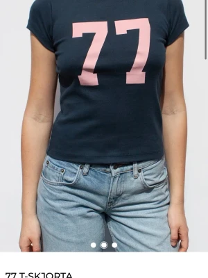 Mörkblå t-shirt med rosa 77-tryck - Snygg mörkblå t-shirt från Subdued med stort rosa 77-tryck på bröstet. T shortsen sitter jätte snyggt men har tyvärr bara kommit till användning en gång. 💕