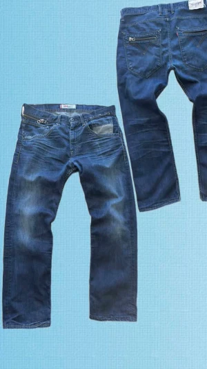 Levi 504 straight jeans - Levi’s 504 Straight jeans  Snygga Levi’s 504 Straight i mörkblå tvätt med coola dragkedjedetaljer på fram- och bakfickorna som ger en unik look. Fina naturliga slitningar och fading som ger karaktär. Bra skick och skön passform som passar både till vardag och festligare tillfällen.  Mått (plagget liggande):  * Midja (A): 44 cm * Längd (B): 100 cm * Benöppning (C): 20 cm  ✔ Original Levi’s ✔ Modell: 504 Straight ✔ Mörkblå tvätt ✔ Dragkedjedetaljer ✔ Bra skick  Skickas väl emballerat.