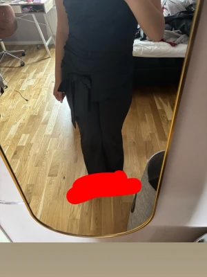 Svarta leggings med knytband - Säljer ett par svarta leggings med snyggt knytband i midjan. De har en smickrande passform och är tillverkade i ett stretchigt material som sitter bekvämt. Perfekta för dig som gillar stilrena och trendiga plagg.