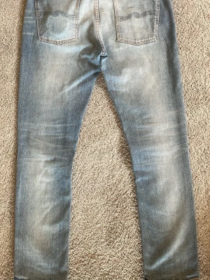 Nudie jeans lean dean  - Säljer ett par galet schysta nudie jeans i modellen Lean Dean. Dem är i storlek W31 L 30 men L representerar mer L 32. Nudie har personligen lagat jeansen vilket kan höja värdet på dem. Jeansen har även en väldigt snygg snusdosefade på vänster bakficka. Jeansen är i toppskick med inga synliga defekter. Hör av er vid frågor eller funderingar. Priset kan diskuteras vid snabb affär! 