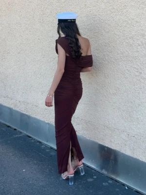 Brun oneshoulder långklänning - Säljer en elegant brun långklänning som jag hade på min mösspåtagning. Den är i jättefint skick, inga skavanker. Perfekt för andra festligheter!