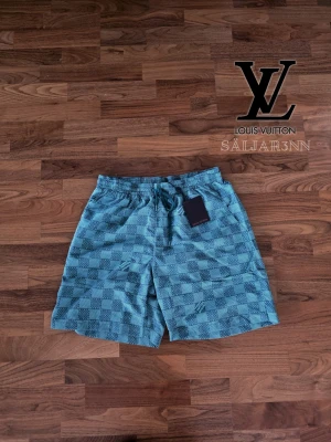 LV Smaragdgröna Badshorts - 🩳 LV Swim Shorts – Storlek M/L 🩳 Stilrena badshorts i blå/grå monograminspirerad design med exklusiv premiumkänsla. Perfekta för strand, pool eller sommaroutfits. Elastisk midja med justerbar dragsko ger bekväm passform i storlek M–L. Lätt och snabbtorkande material med två sidofickor och diskret mönster. Fint skick, sparsamt använda. 📦 Snabb leverans – skickas samma dag (om ej hindr.) 📩 Kontakta vid frågor eller intresse.