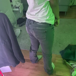 Pepe Grå jeans med låg midja - Säljer ett par grå jeans med låg midja och lite bootcut ben. Jeansen har klassisk femficksdesign, bälteshällor och dragkedjegylf. Snygg tvättad look och passar perfekt till en avslappnad stil. Stilig design på bakfickor.