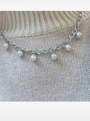 Silverfärgat halsband med pärlor - Snyggt halsband med silverfärgad rostfri kedja och hängande vita pärlor. Kedjan har en chunky look och pärlorna är droppformade, vilket ger en trendig och stilren vibe. Perfekt accessoar för att lyfta din outfit.