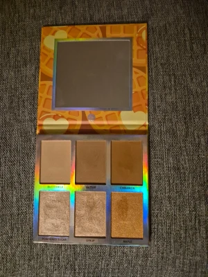 Belgian Waffle highlighterpalett - Säljer en Belgian Waffle highlighterpalett från bh cosmetics med sex nyanser: Buttermilk, Batter, Cinnamon, Powdered Sugar, Syrup och Maple. Paletten har både matta och skimriga puder i varma beige, guldiga och bruna toner. Perfekt för att skapa glow och kontur. Spegel i locket.  Paletten är Swatshad. Fint skick. 