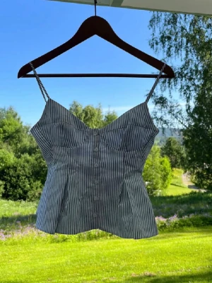 Randig croppad linnetopp från Zara - Säljer en vit och blå randigt linne från Zara som är väldigt eftertraktat. Perfekta för en sommar dag💕