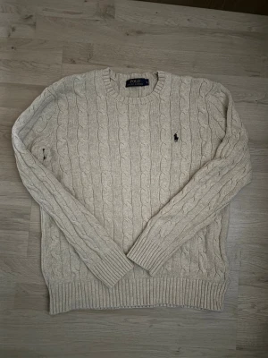 Ralph lauren kabel stickad tröja - Stilren kabel stickad tröja från Ralph lauren! Perfekt för en lågprofil men ren look med asfett mönster.