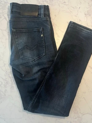 Mörkblå jeans från Replay - Snygga mörkblå jeans från Replay med klassisk femficksdesign och diskret logga på bakfickan. Jeansen har raka ben och är tillverkade i mjuk denim med lätt tvättad look. Perfekta för en stilren och avslappnad outfit.