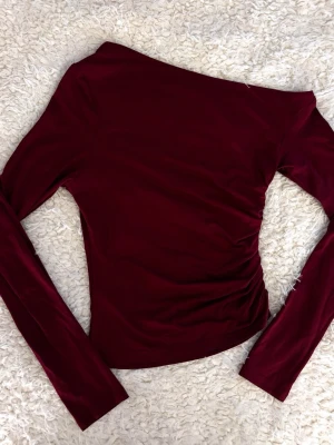 Vinröd Asymmetrisk Tröja - Snygg och unik tröja i vinrött med asymmetrisk design ✨ Aldrig använd, i helt nyskick. Perfekt för både vardag och fest och enkel att styla med olika outfits❤️Pris kan diskuteras 