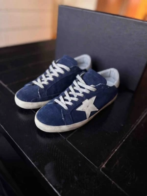 Golden Goose Superstar – Navy | Strl 44 | Mycket Gott Skick - Golden Goose Superstar i navy — ikonisk italiensk lyx med signatur distressed finish, handgjord av hantverkare i Venedig. Mycket gott skick med minimalt slitage. ✅ Dustbag ✅ Skriv i DM för kvitto — vi håller det privat för att skydda köparens personliga information Storlek 44. Vi tar även emot byten och uppgraderingar. Kan även köpas via www.nordens.store med Klarna & Paypal. Vi reparerar, renoverar & rengör även skor — skriv i DM! 👟 📦 Spårad frakt, väl förpackad.