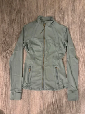  Lululemon define luon  - Lululemon Fog Green Luon Define Jacket with Gold Hardware 🌿✨ The most gorgeous sage/matcha green shade paired with stunning gold zippers! This is the super soft Nulu fabric version. It’s in perfect condition/like new and provides that iconic snatched silhouette. Such a "mint moment" for your gym or hot girl walk outfits!  * Brand: Lululemon * Size: 4 or XS * Color: Fog Green * Condition: worn once Feel free to message me with any questions 💌  #lululemon #definejacket #foggreen #athleisure #pilat